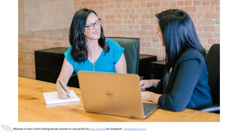 Two women sitting together with a laptop.